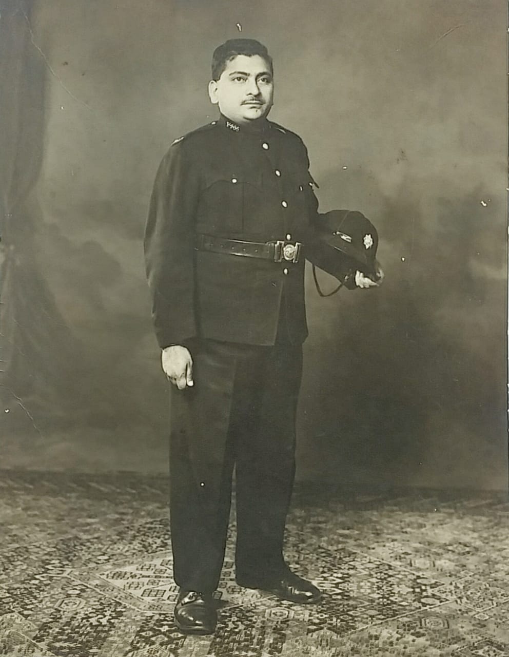 A person in a uniform holding a hat AI-generated content may be incorrect.
