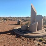 A stone sculpture in a desert AI-generated content may be incorrect.