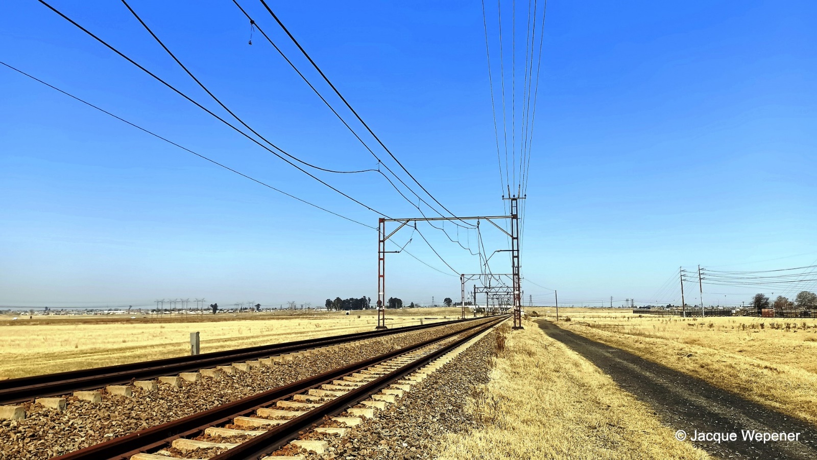 A train tracks with power lines AI-generated content may be incorrect.