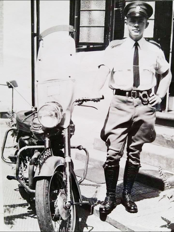 A person in uniform standing next to a motorcycle

AI-generated content may be incorrect.