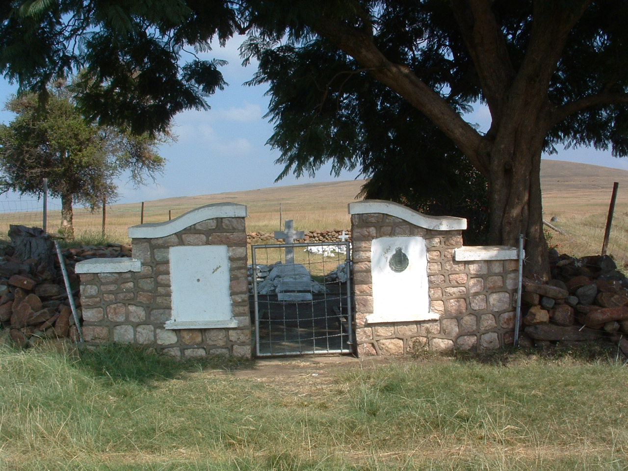 A stone gate with a tree in the background

AI-generated content may be incorrect.