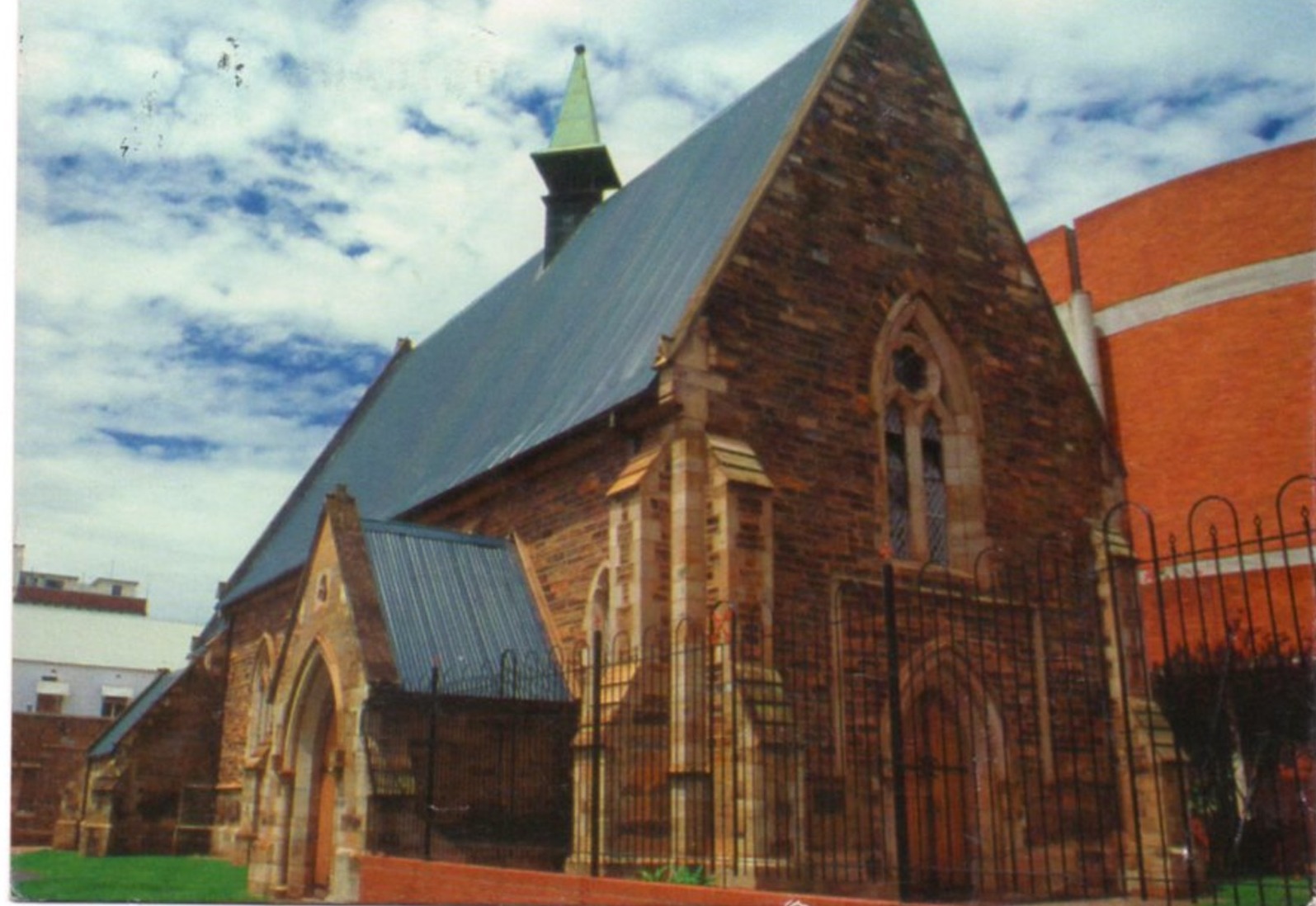 A brick church with a black fence
AI-generated content may be incorrect.