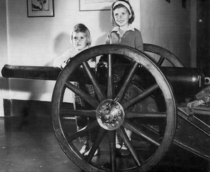 A couple of children standing behind a wheel

AI-generated content may be incorrect.