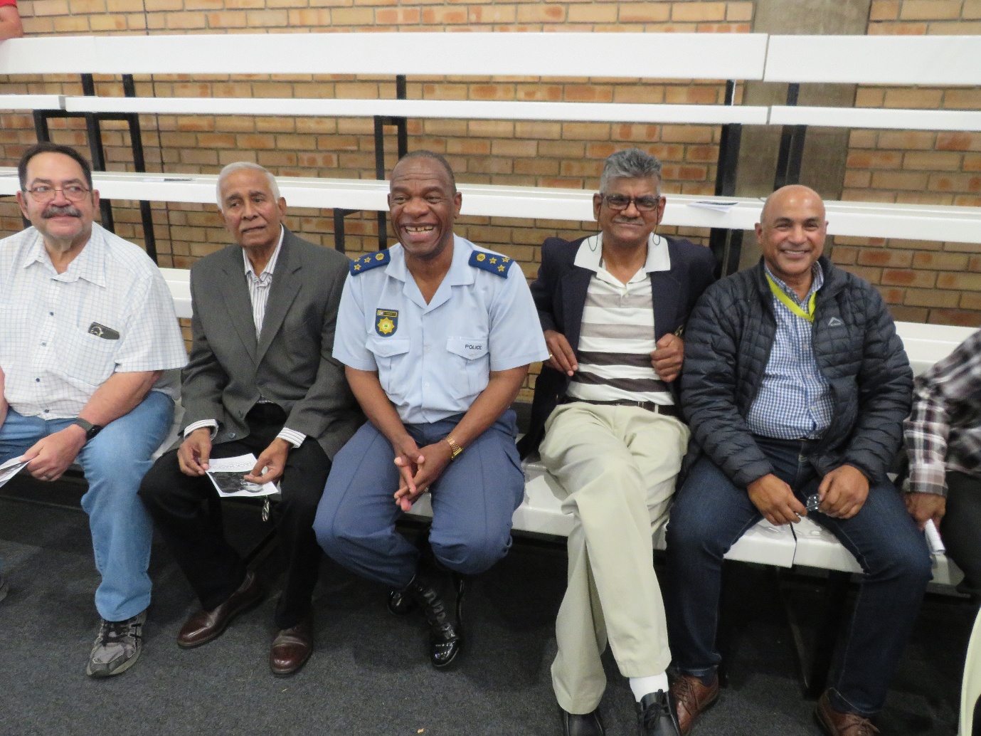 A group of men sitting on a bench AI-generated content may be incorrect.
