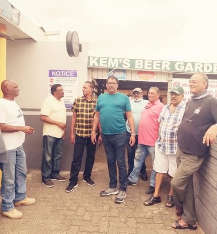 A group of men standing in a line outside a building AI-generated content may be incorrect.