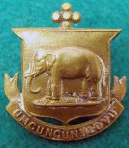 A gold elephant emblem on a green surface AI-generated content may be incorrect.