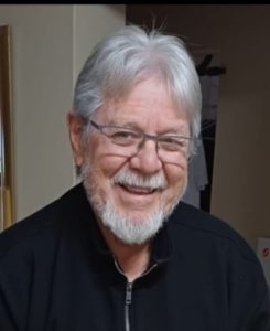 A person with white hair and beard smiling

AI-generated content may be incorrect.