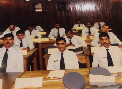 A group of men in uniform sitting at desks AI-generated content may be incorrect.