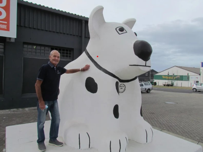 A person standing next to a statue of a dog

AI-generated content may be incorrect.