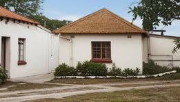 A white house with a brown roof AI-generated content may be incorrect.