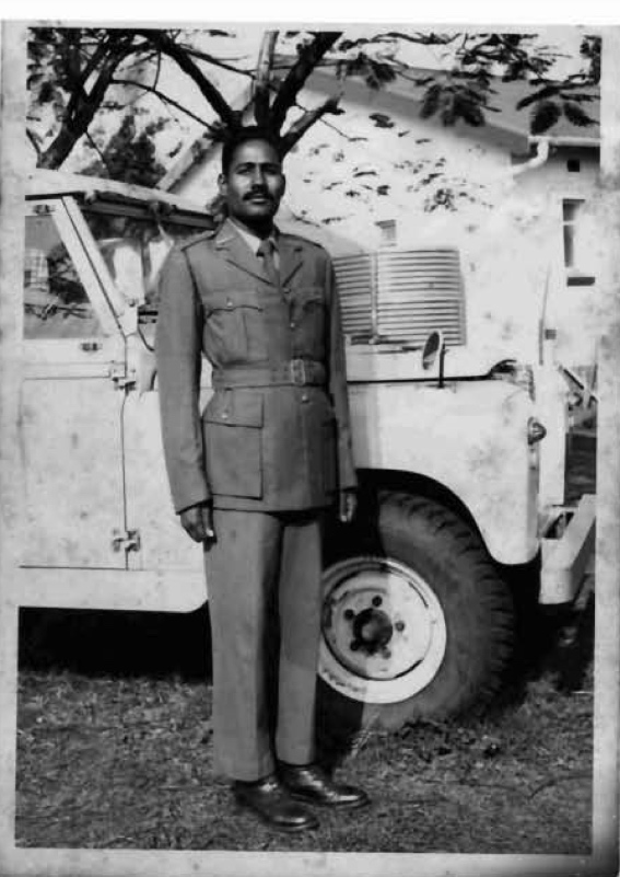 A person in a military uniform standing in front of a jeep
AI-generated content may be incorrect.