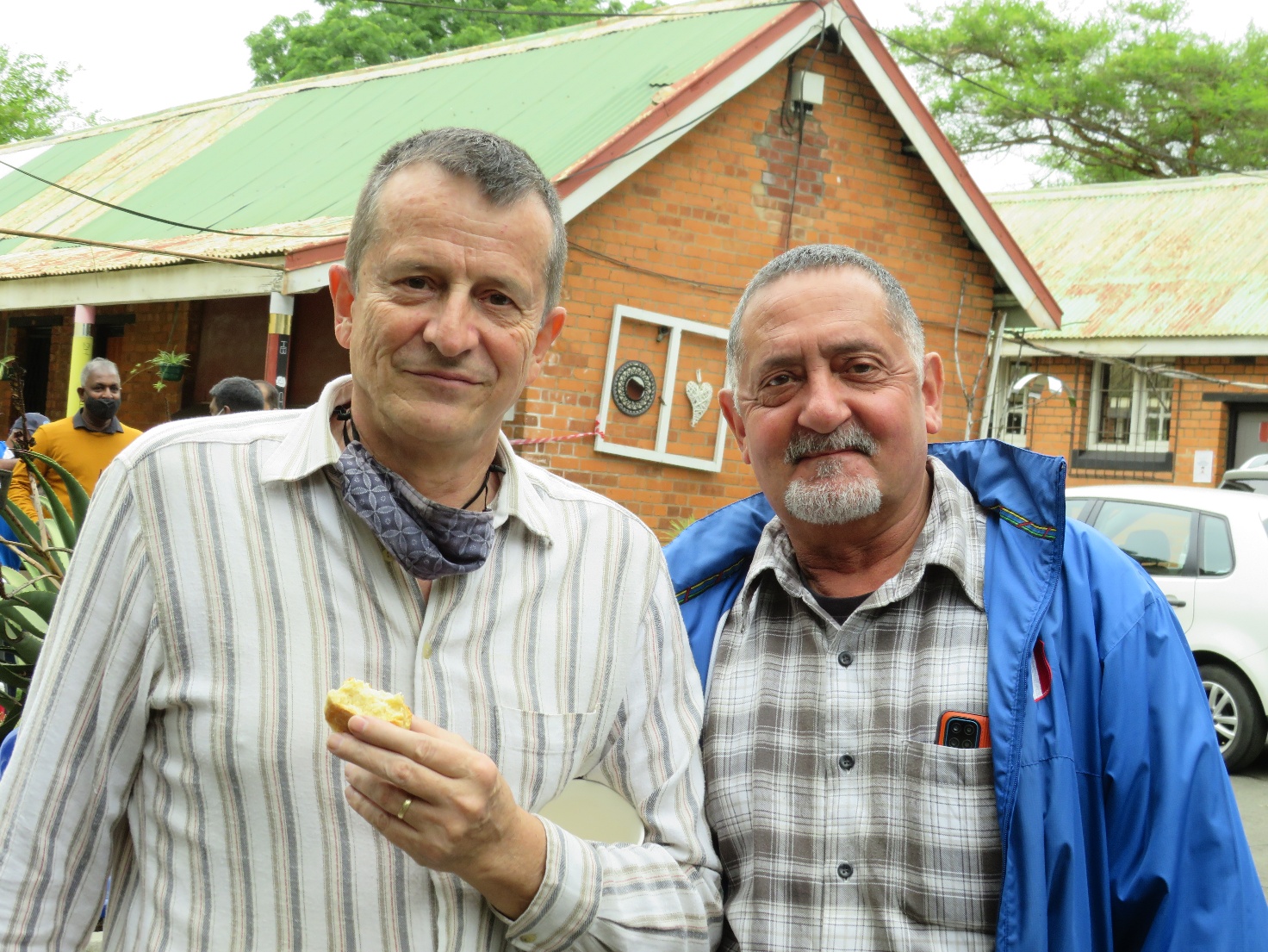 A couple of men standing outside a building AI-generated content may be incorrect.