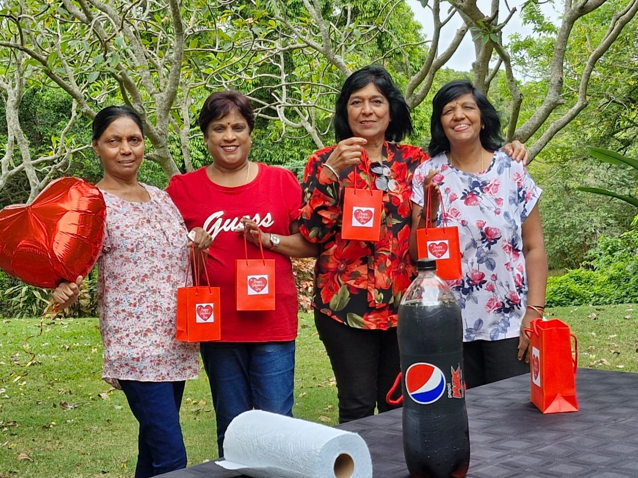 A group of women standing outside with bags and balloons
AI-generated content may be incorrect.