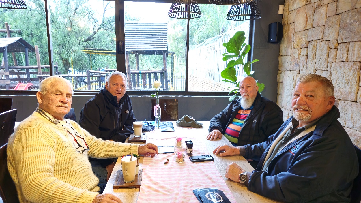 A group of men sitting at a table AI-generated content may be incorrect.