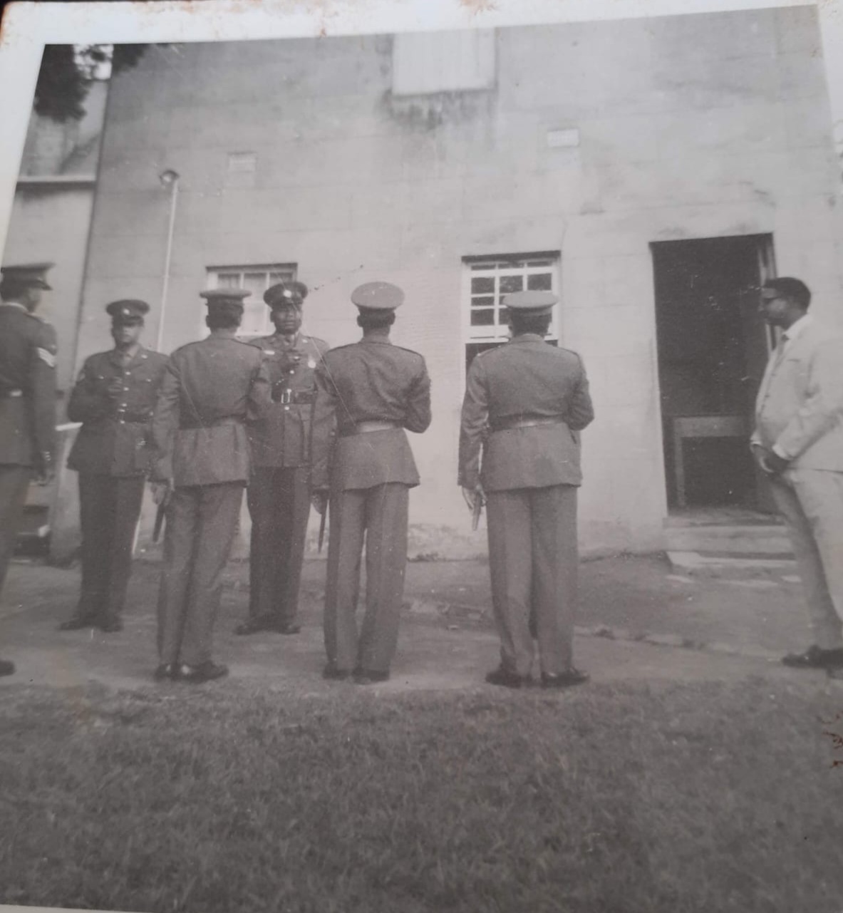A group of men standing in front of a building AI-generated content may be incorrect.