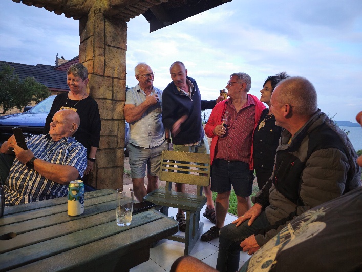 A group of people standing around a table AI-generated content may be incorrect.