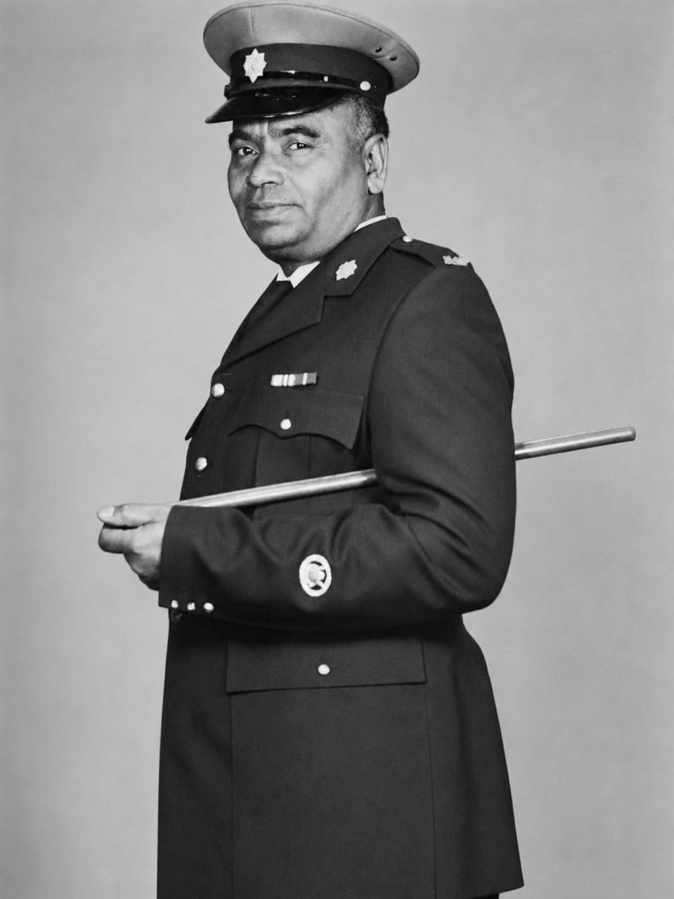 A person in a uniform holding a baton AI-generated content may be incorrect.