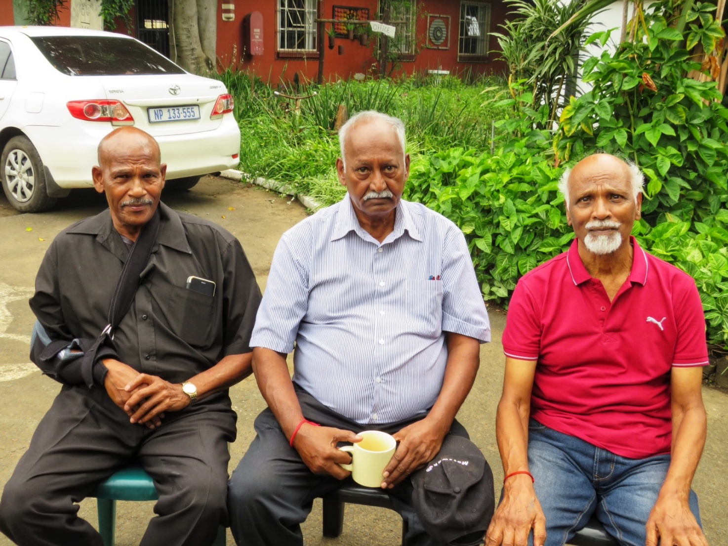 A group of men sitting on benches outside
AI-generated content may be incorrect.