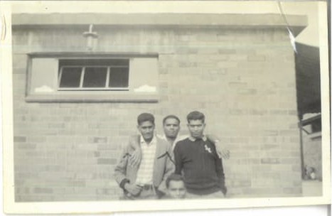 A group of men standing in front of a brick building
AI-generated content may be incorrect.